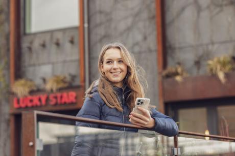 Nainen ulkona puhelimen kanssa